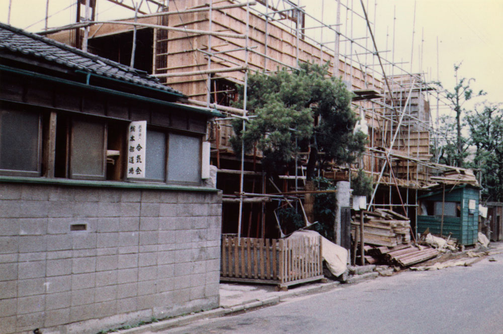 Chantier de construction du bâtiment en béton à côté de l'ancien dojo.